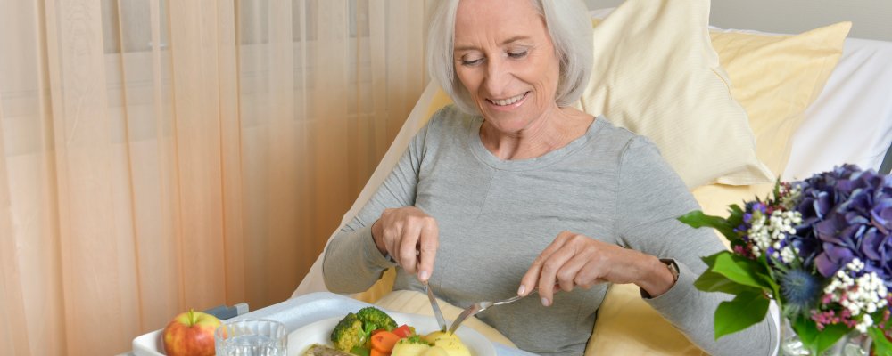 Ältere Dame im Krankenhausbett beim essen