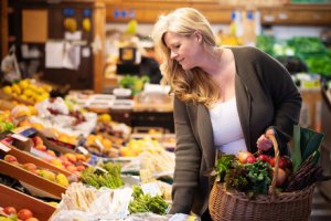 Frau kauft frisches Gemüse