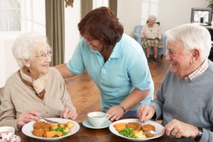 Älteres Ehepaar bekommt Essen von einer Pflegekraft gereicht