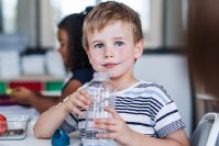 Junge trinkt Wasser in Klassenzimmer