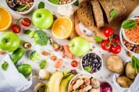 frisches Obst und Gemüse, Hülsenfrüchte und Brot auf einem Tisch