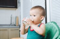 Kleinkind trinkt Milch aus dem Glas