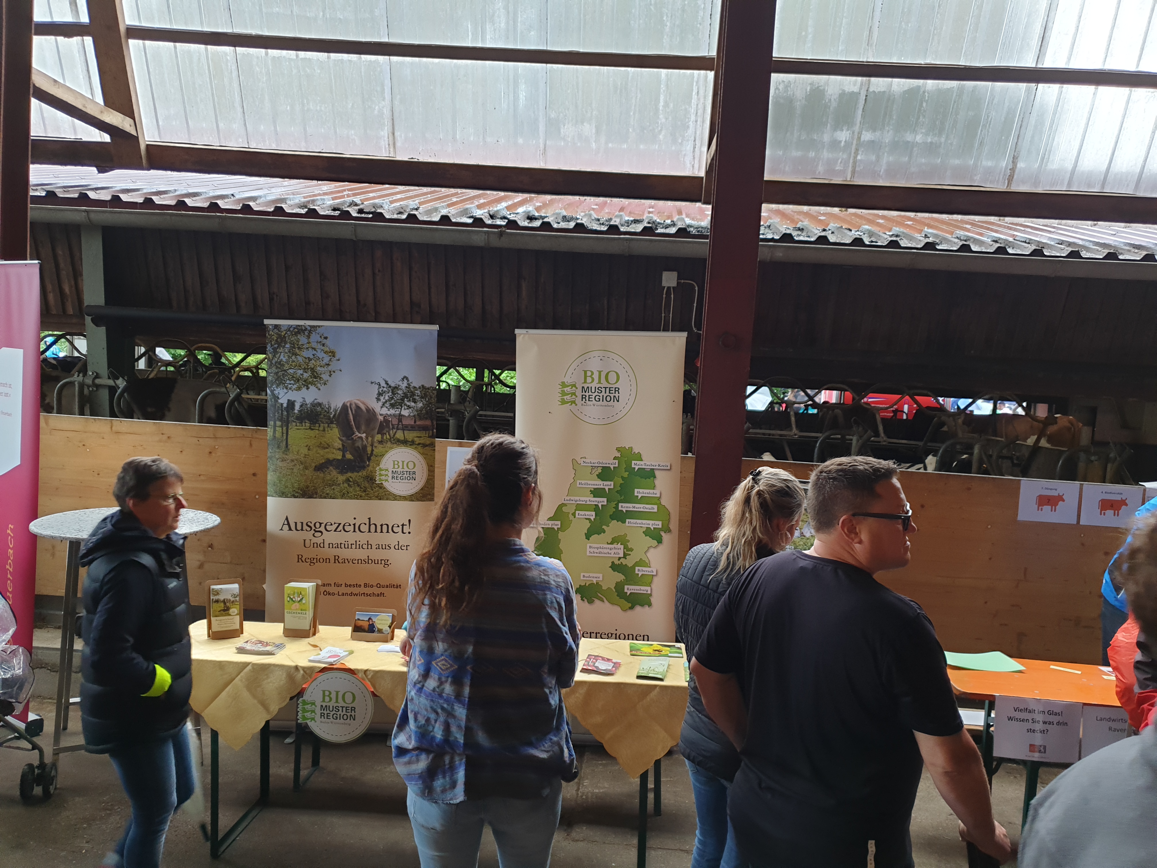 Infostand der Bio-Musterregion Ravensburg bei der Gläsernen Produktion mit interessierten Besucherinnen und Besuchern vor dem Stand