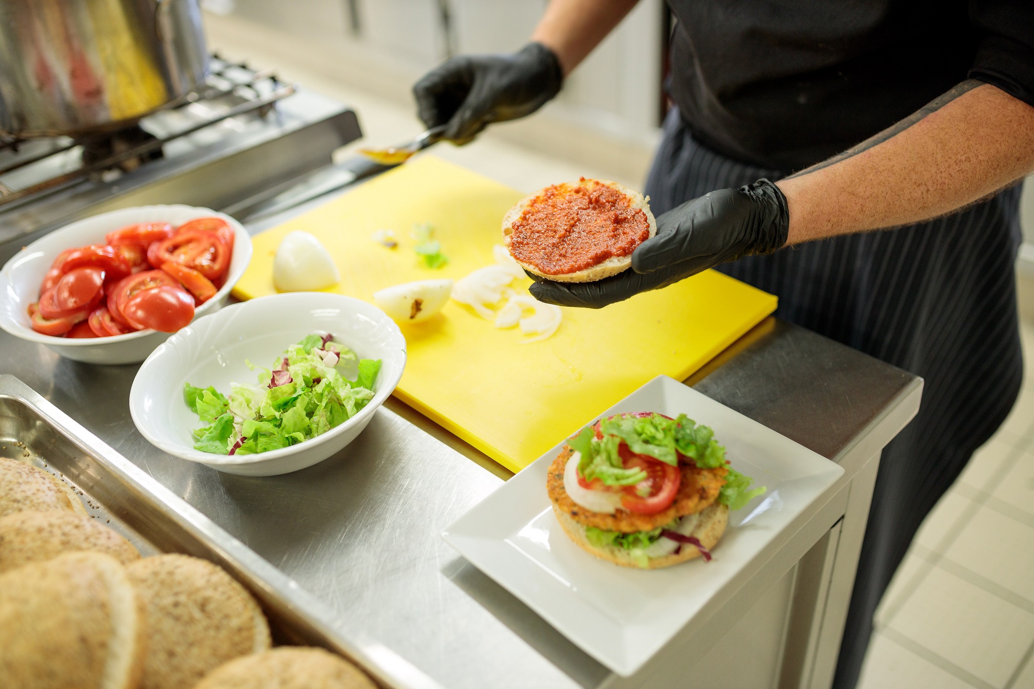 Aus frischen Lebensmitteln wird ein Burger zubereitet