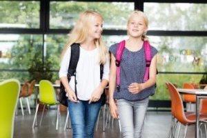 Zwei Mädchen gehen in die Mensa ihrer Schule